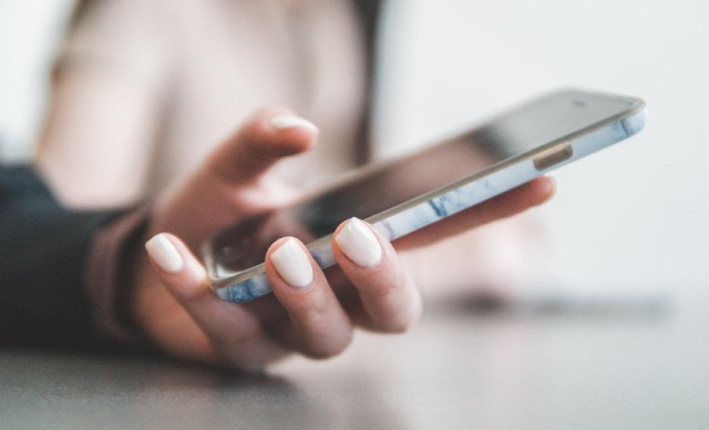 Person using their phone to access the best texting software for nonprofits